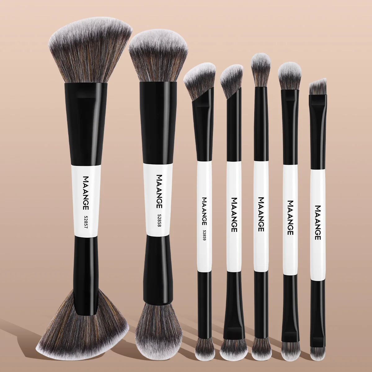 Set of eight makeup brushes with black and white handles on a beige background