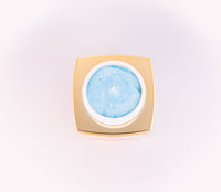 Cosmetic cream in a gold container on a light pink background